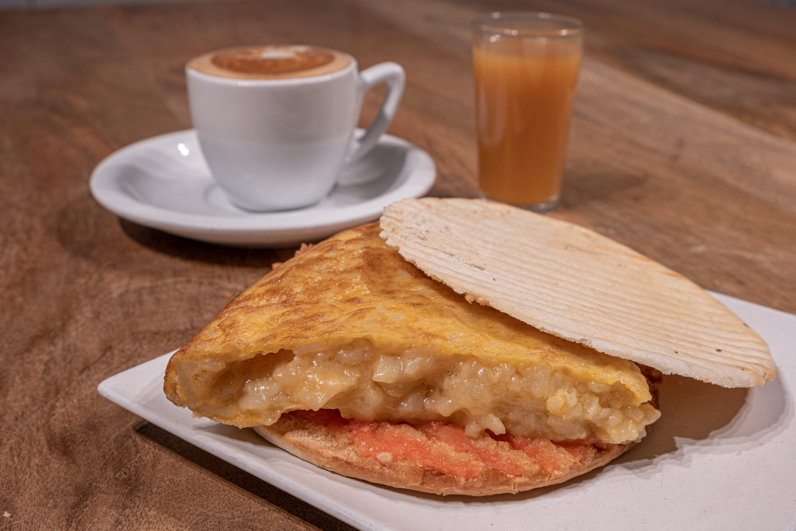 Desayuno Piraña compuesto por un mollete con tomate triturado y tortilla de patatas acompañado de zumo y café
